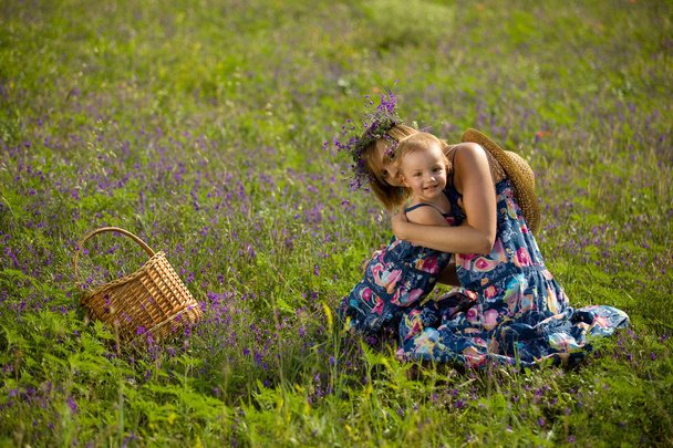 Happy mother playing with daughter in field - Photo, Image