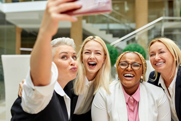 portrait of happy group of women taking photo on mobile phone - Zdjęcie, obraz