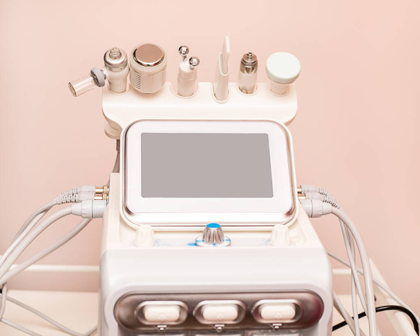 Bevestigingen aan apparaat HydraFacial gezichtsverzorging machine in spa kliniek voor anti-aging of acne behandeling. Het concept van esthetische geneeskunde, schoonheidsmiddelen, de nieuwste technologieën in de schoonheidsindustrie - Foto, afbeelding