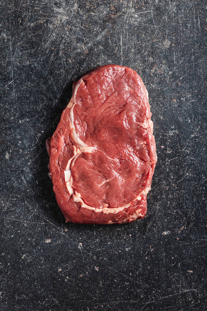 Sliced raw ribeye steak on a black kitchen table. Top view. - Фото, изображение