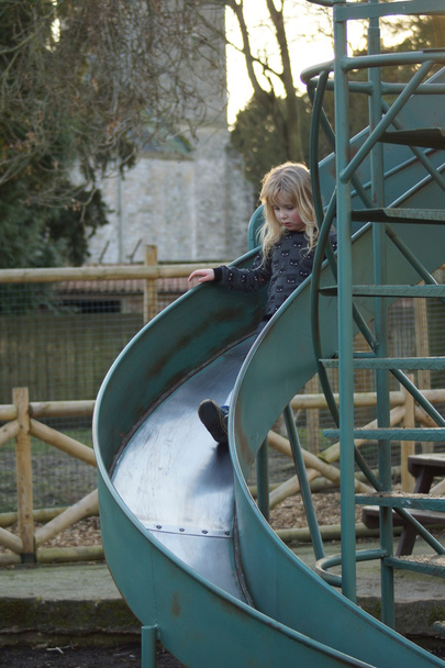 Little girl on big blue slide - Photo, Image