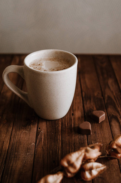 暗い木製の背景にミルクコーヒーとチョコレート - 写真・画像