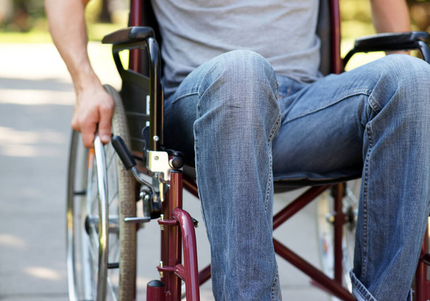 Muž s postižením chůze musí sedět na invalidním vozíku po autonehodě - zblízka záběr venku v parku  - Fotografie, Obrázek