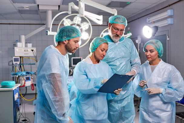 portrait of confident professional surgeons talking at work place - Fotografie, Obrázek
