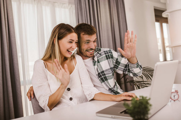 Couple with laptop spending time together at home - Photo, image