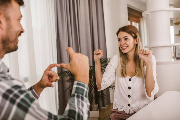 Casal jovem conversando usando linguagem gestual em casa. - Foto, Imagem