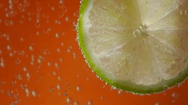 ασβέστη σε νερό σόδα σε πορτοκαλί φόντο - Πλάνα, βίντεο