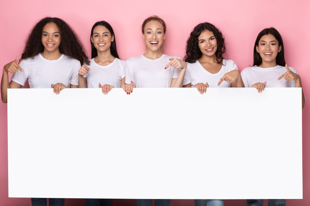 Donne che detengono vuoto cartone in piedi su sfondo rosa Studio - Foto, immagini