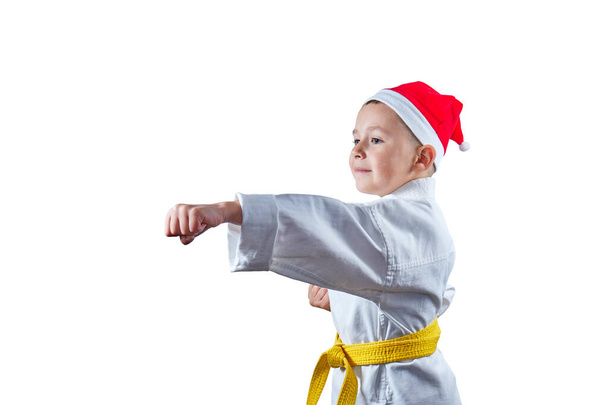 Little sportsman in Santa's hat beats a punch - Photo, Image