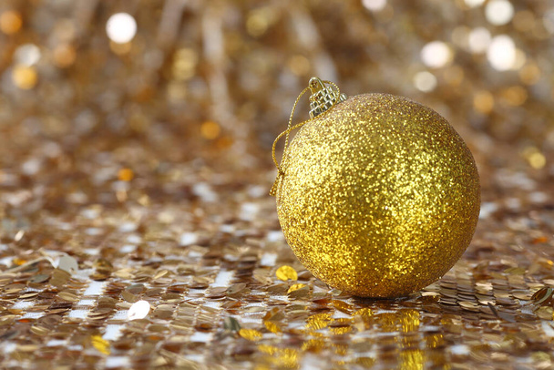 Golden christmas ball on glitter background - Фото, зображення