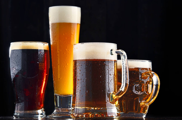 Four glassed of beer on wooden background. - Foto, imagen