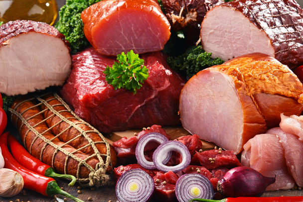 Różnorodność produktów mięsnych, w tym szynki i kiełbasy. - Zdjęcie, obraz