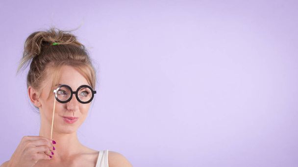 Elegant young woman pretending wearing funny nerd eyeglasses. Education and studying females look concept. - Foto, immagini