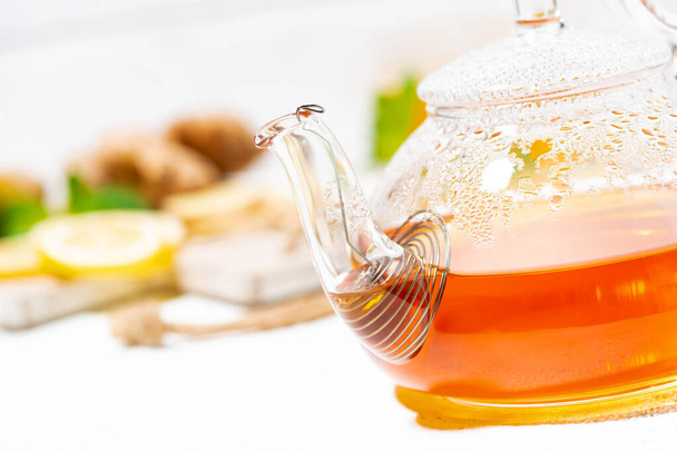 glass teapot of tea with lemon, ginger and mint to enhance immunity, closeup - Fotografie, Obrázek