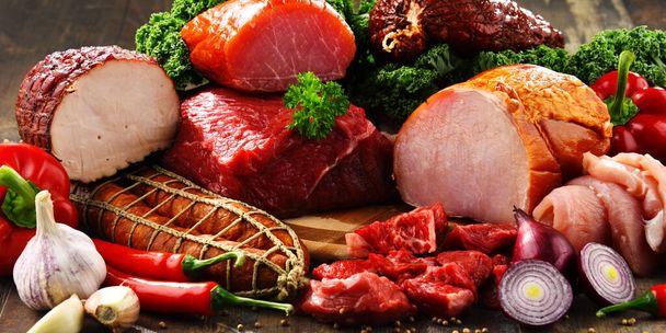 Varietà di prodotti a base di carne tra cui prosciutto e salsicce. - Foto, immagini