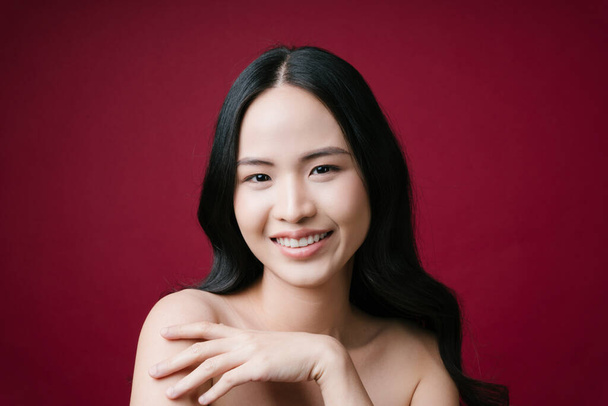 Mooie aziatische vrouw gezonde huid concept natuurlijke make-up isoleren op rode achtergrond. - Foto, afbeelding