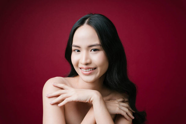 Ritratto di bellezza donna asiatica capelli neri pelle sana naturale isolato su sfondo rosso. - Foto, immagini