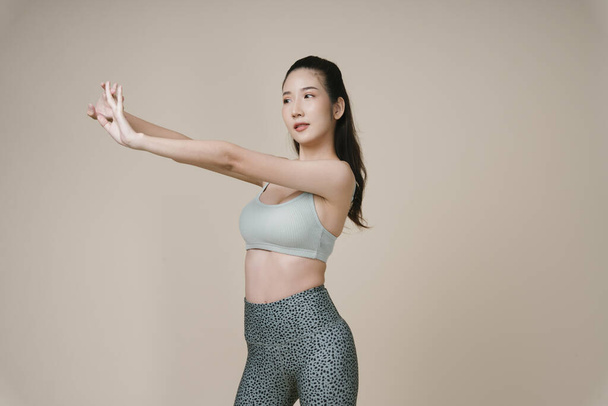 Retrato de hermosa joven asiático deportivo mujer desgaste deporte sujetador estiramiento manos arriba. - Foto, imagen