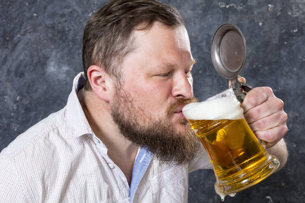 Matured smiling bearded man in shirt with beer mug - Photo, Image