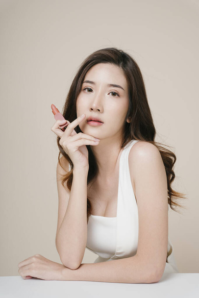 Portrait de belle jeune femme asiatique avec rouge à lèvres beige. - Photo, image