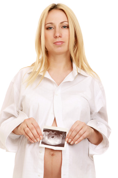 Pregnant woman holding an ultrasound picture of her baby - Fotoğraf, Görsel
