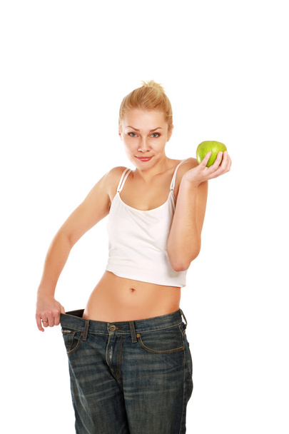 Young girl with big jeans and apple - Foto, Imagem