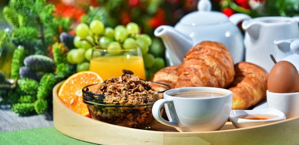 Frühstück mit Kaffee, Orangensaft, Croissants, Müsli und Obst im Garten - Foto, Bild