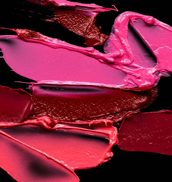 Different lipstick colors smudges over black background - Photo, Image