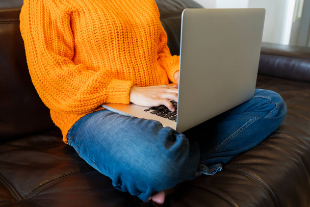 mulher sem rosto usando computador no sofá em casa - Foto, Imagem
