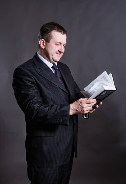 Middle aged solid tutor with book - Φωτογραφία, εικόνα