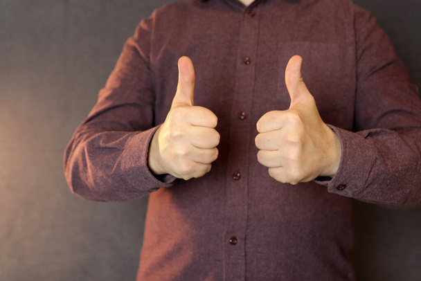 two male hands show thumbs up on a dark background - Fotoğraf, Görsel
