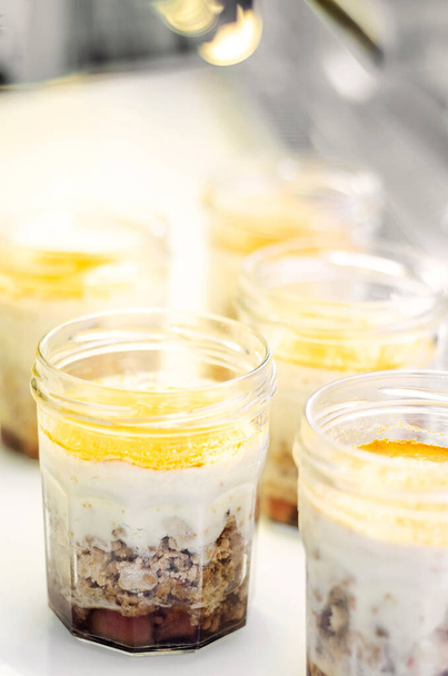 органические яблоко и кокосовый веганский чизкейк десерт в стеклянную банку варенья в кафе дисплей - Фото, изображение
