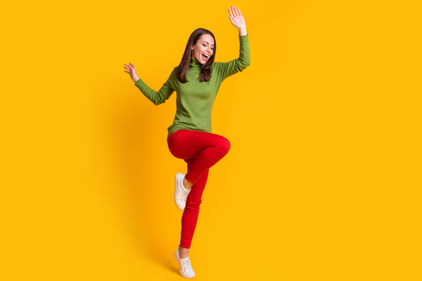 Full length body size view of nice careless cheerful girl jumping having fun dancing free time isolated bright vibrant yellow color background - Zdjęcie, obraz