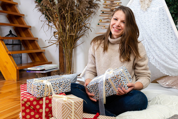 young woman wrapping gifts at home, packing presents for christmas, prepare for coming up new year and xmas - Foto, immagini
