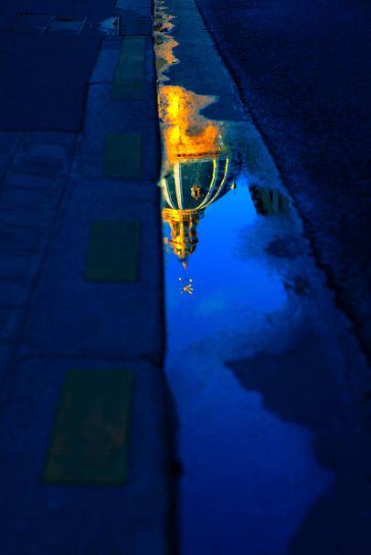 Altın kilise kubbesi asfalttaki yağmur havuzuna yansıdı.  - Fotoğraf, Görsel