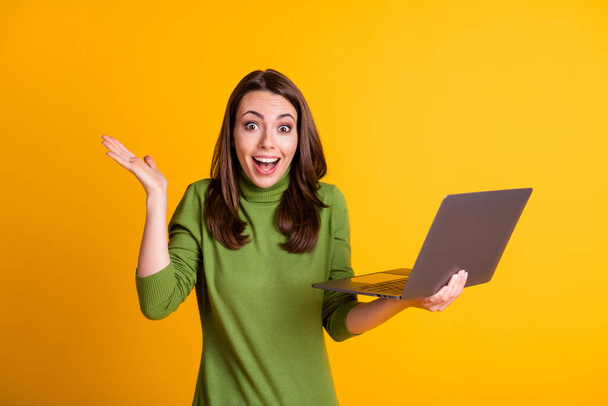 Photo of pretty excited lady freelancer hold notebook open mouth wear green sweater isolated yellow color background - Φωτογραφία, εικόνα