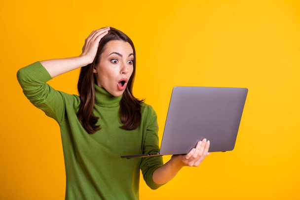 Photo of shocked lady freelancer worker hold notebook open mouth wear green sweater isolated yellow color background - Фото, зображення