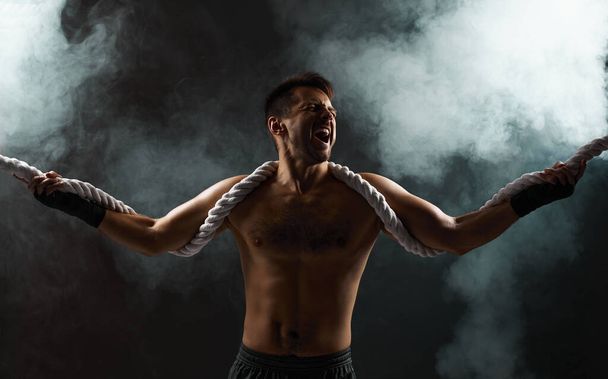 strong athletic muscular man with naked body holding rope - Fotografie, Obrázek