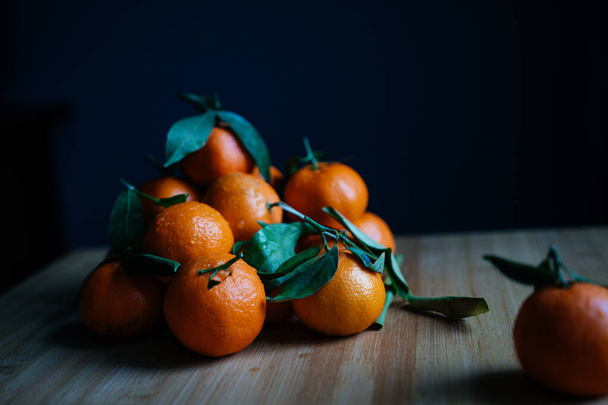 mandarinas naranjas con hojas sobre un fondo beige, estado de ánimo de año nuevo, Navidad, año nuevo - Foto, imagen