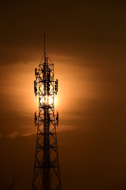 Τηλεπικοινωνιακός Πύργος Κεραίες High Pole Signal Transmission Wireless Phone ', Κεραία ασύρματης επικοινωνίας Με την ανατολή του ηλίου φωτεινό ουρανό.Τηλεπικοινωνιακός πύργος με κεραίες με πορτοκαλί ουρανό. - Φωτογραφία, εικόνα