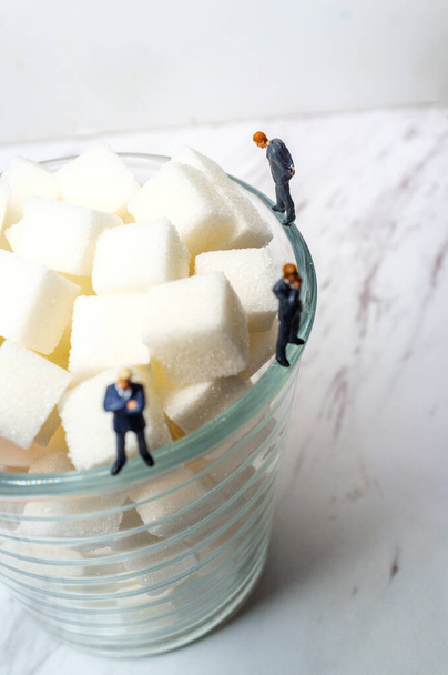Концептуальные кубики сахара в стекле и диабет бизнесменов концептуальная метафора - Фото, изображение