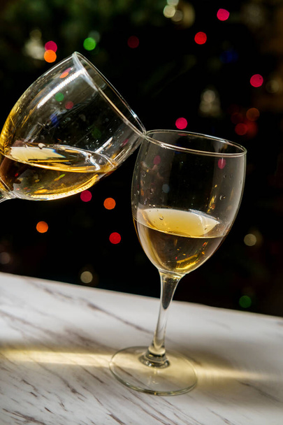 Καλές γιορτές δύο ποτήρια κρασί clinking μαζί με το φως των Χριστουγέννων bokeh φόντο - Φωτογραφία, εικόνα