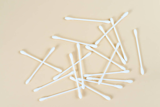 Los brotes de algodón blanco con el tallo blanco esparcidos sobre un fondo beige - Foto, imagen