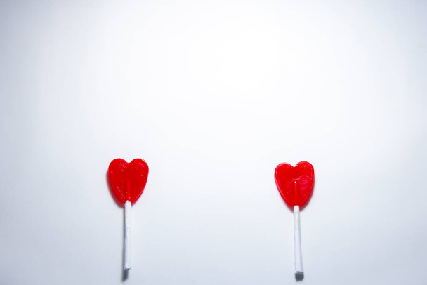 Cenital plane. Two heart-shaped lollipops separated from each other. Valentine's Day concept during the Covid-19 pandemic and safety distance - Foto, imagen