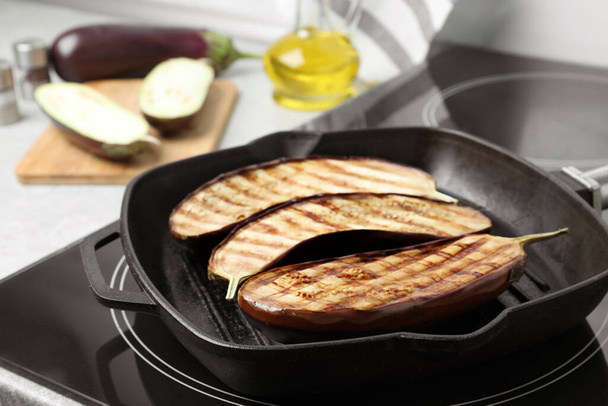 Delicious grilled eggplant halves in pan on stove, closeup - Foto, immagini