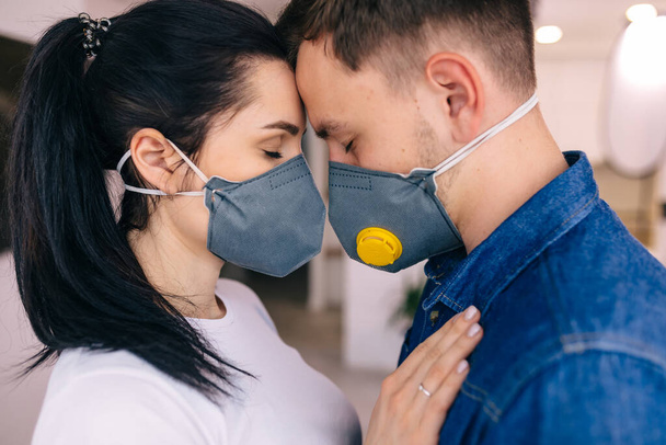 νεαρό ζευγάρι με ιατρικές μάσκες για προστασία από εποχιακές λοιμώξεις, κρυολογήματα, και coronavirus. Έννοια υγείας και υγειονομικής περίθαλψης - Φωτογραφία, εικόνα