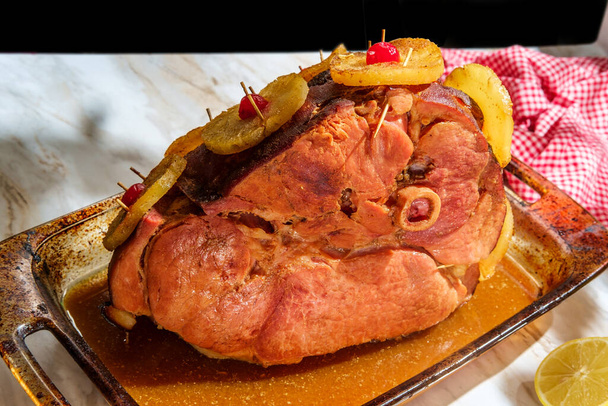 Roasted bone in ham dinner in glass casserole with pineapple slices and maraschino cherries - Photo, Image