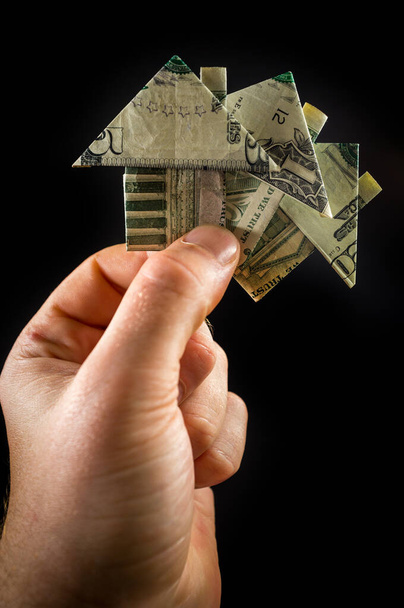 Hand κατέχει origami χάρτινο σπίτι χρήματα για την έννοια της αγοράς ακινήτων και κατοικιών - Φωτογραφία, εικόνα