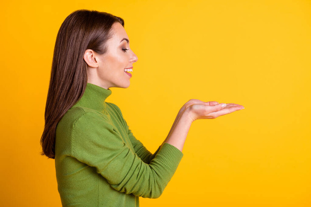 Profile photo of attractive lady hold open arms empty space wear casual green sweater isolated yellow color background - 写真・画像