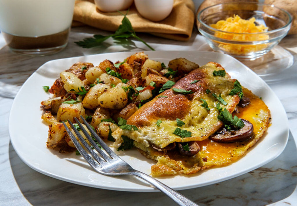 American breakfast mushrooms and cheddar cheese omelette with home fries and milk - Fotó, kép